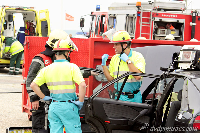 Doctor and firefighter discussing the situation on this vehicle that has crashed against the red object.