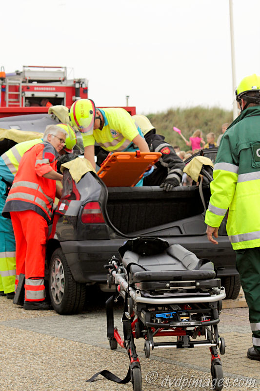 The victim is carefully placed on the orange plank, to move her to the stretcher.