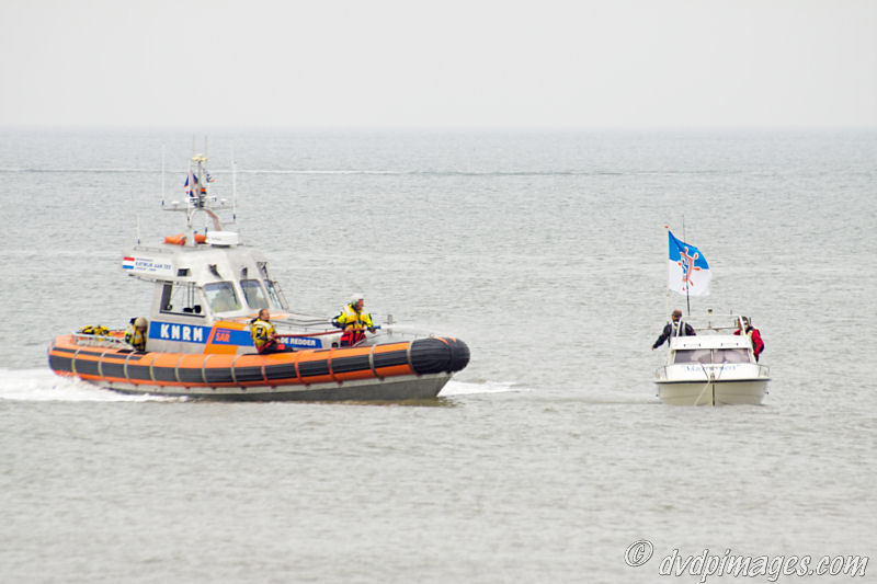 A small boat with problems. The rescue ship has a hose on board for small fires.