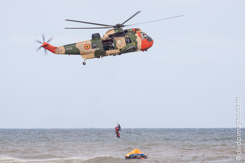 A victim is taken from a rescue float onto a Sea King helicopter.